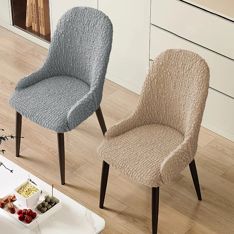 Beige curved chair with arm covers in a modern dining room – soft, breathable, and protective slipcover handcrafted by Plume Bubble.